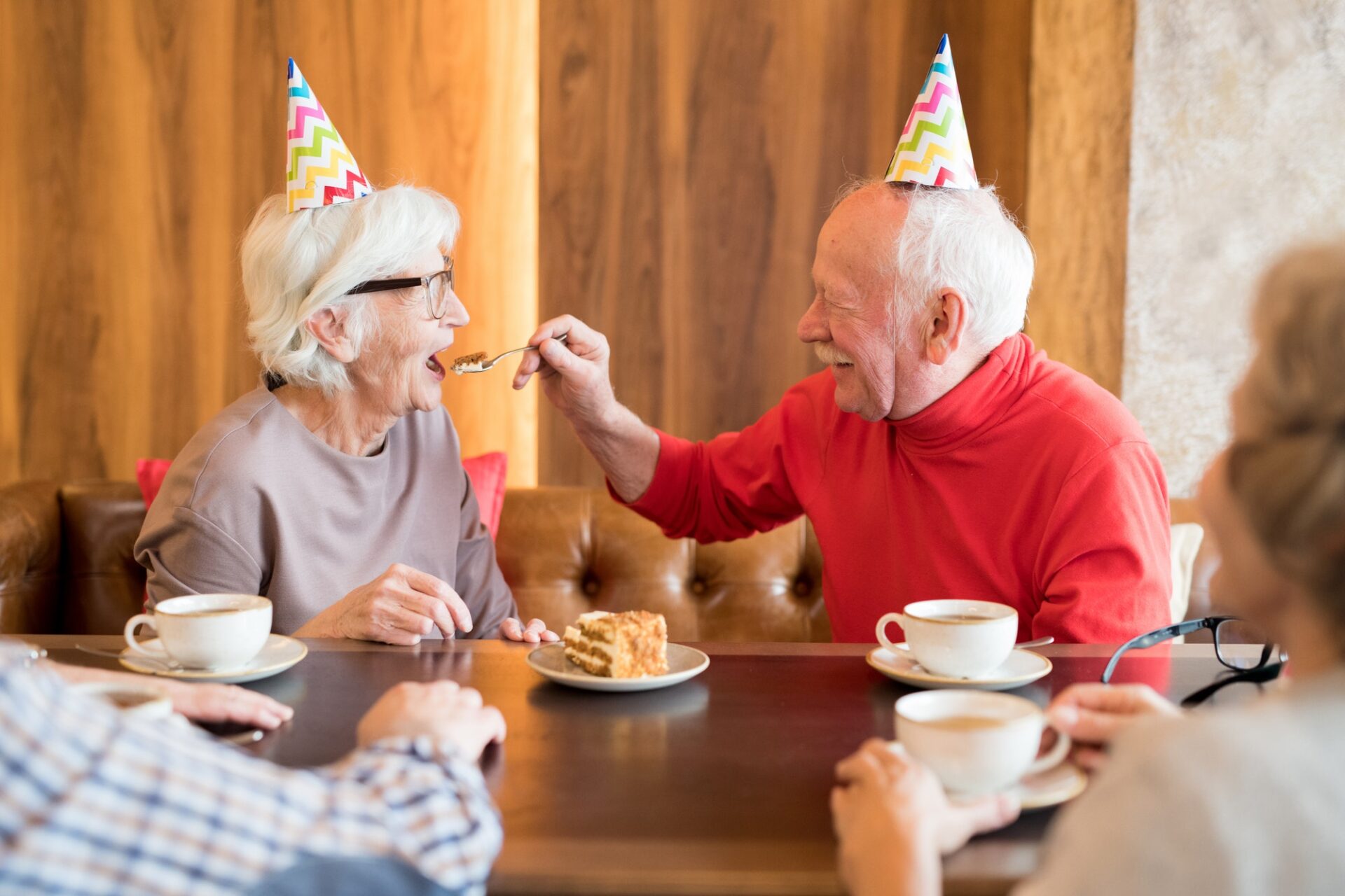 Careful senior husband feeding birthday wife