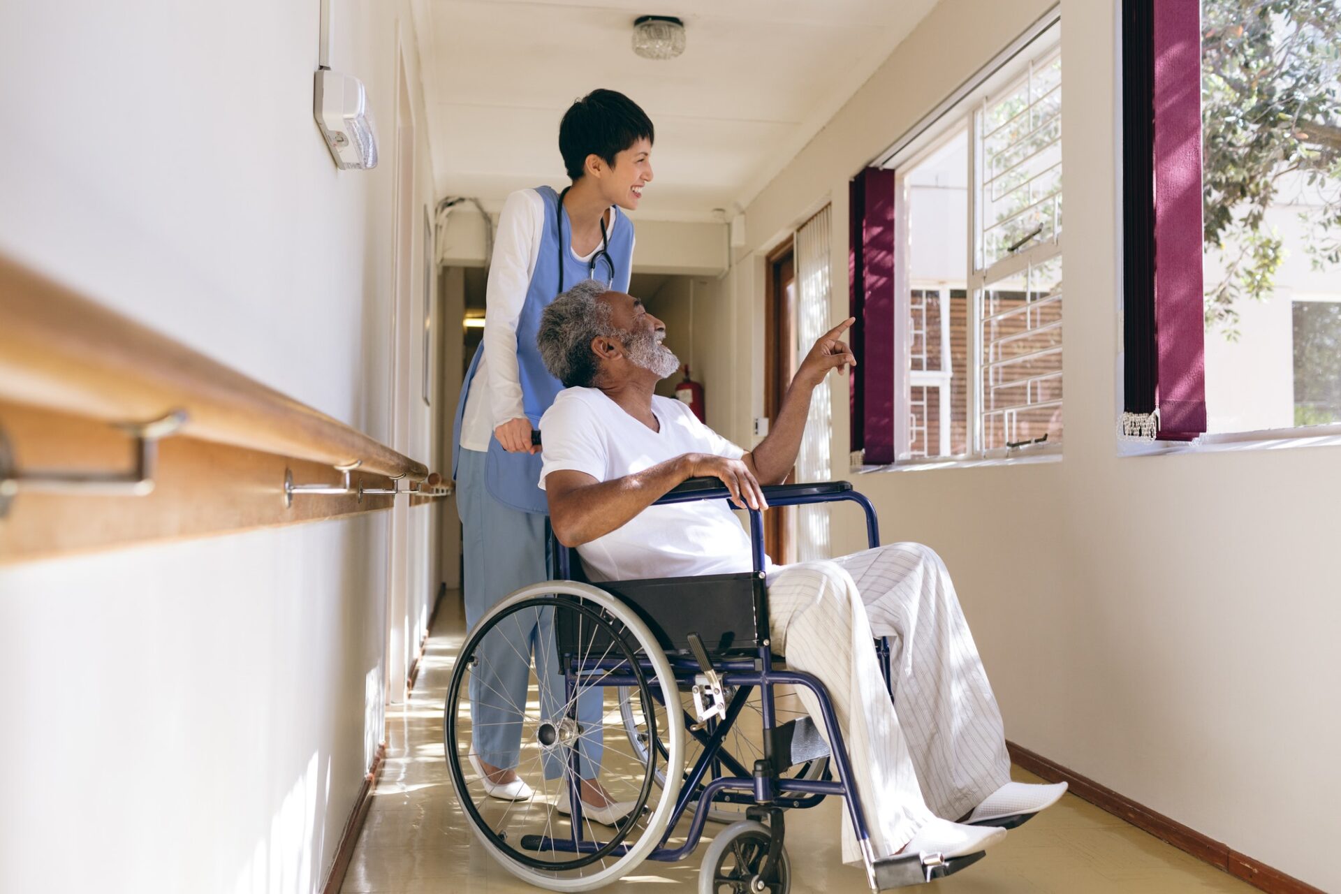 Female nurse and senior male patient interacting with each other at retirement home