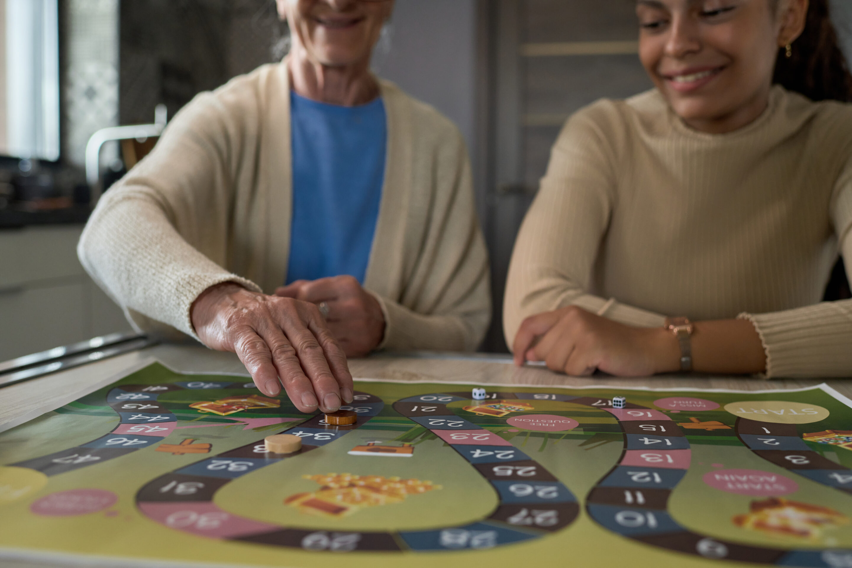 Hand of senior woman moving small round chip along board game