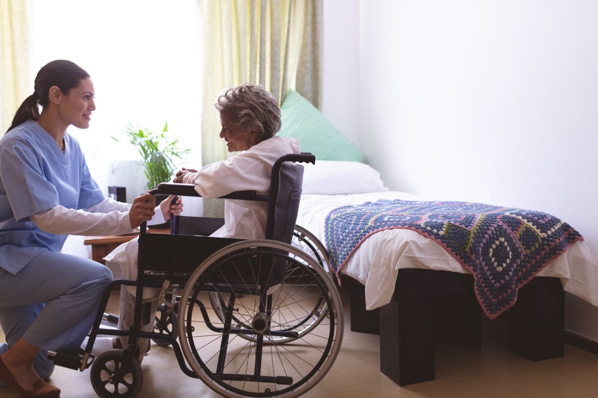 Nurse talking with senior female patient at nursing home