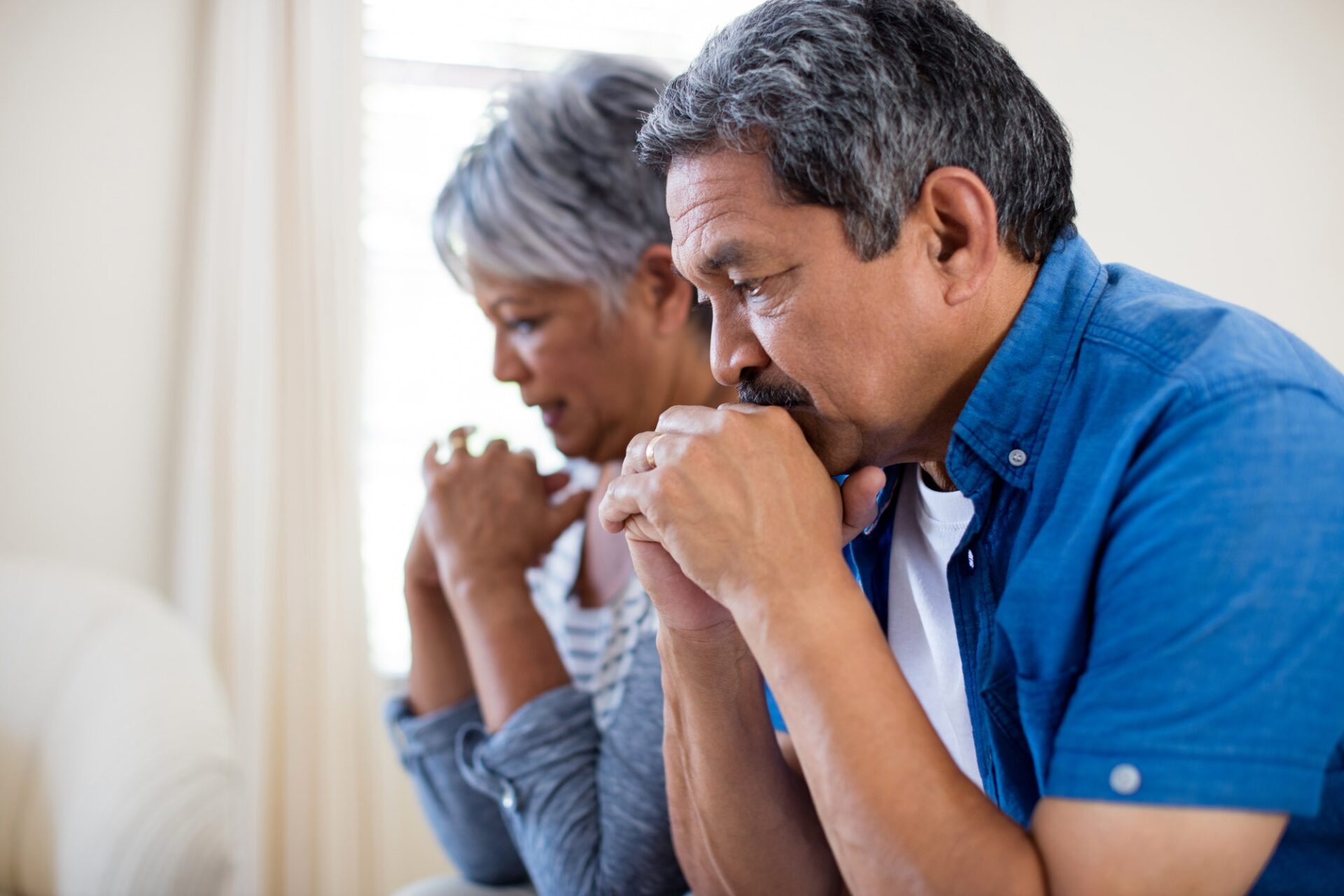 Tensed senior couple in living room